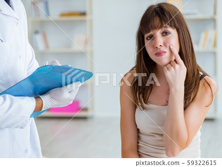 Doctor examining the skin of female patient 59322615