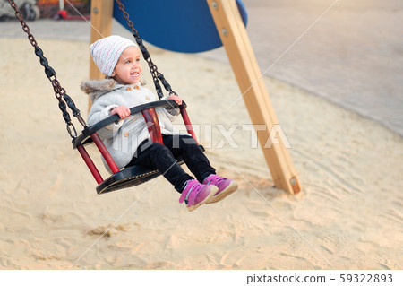 Happy child girl on swing in sunset fall. Little 59322893