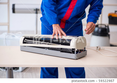 Young male contractor repairing air-conditioner at workshop 59322987