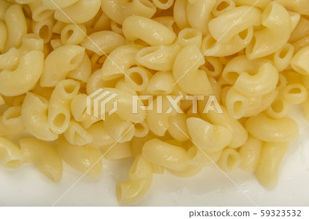 Boiled yellow pasta on a white plate. Boiled yellow pasta on a white plate. 59323532