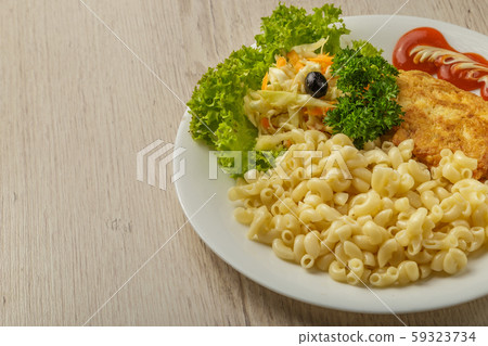 Pasta with a piece of grilled meat and salad. 59323734