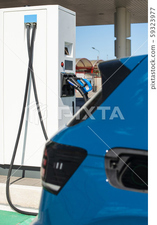 Electric car on gas station. Blue car and electric Electric car on gas station. Blue car and electric 59323977