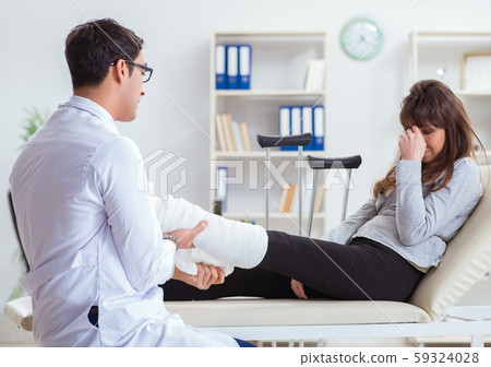 Doctor examining patient with broken leg 59324028