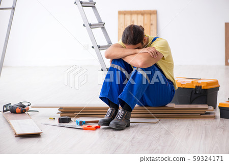 Young male contractor working indoors Young male contractor working indoors 59324171