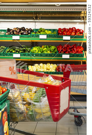 Shopping cart in supermarket in front of shelf 59324332