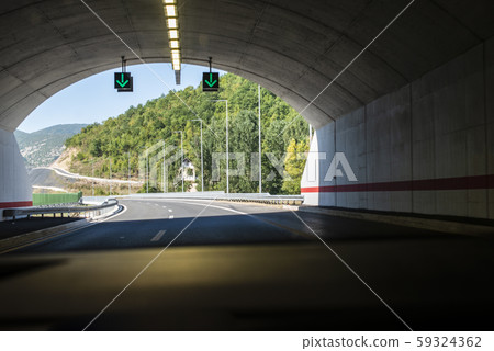 Highway tunnel. Signs in tunnel. Mountain road. Highway tunnel. Signs in tunnel. Mountain road. 59324362