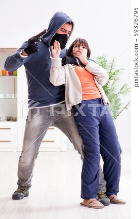 Armed man assaulting young woman at home 59326795