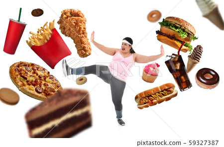 Overweight Asian woman fighting off junk food isolated on white background 59327387