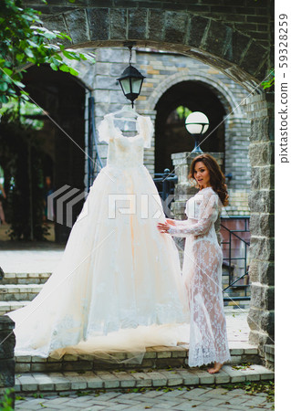 Young beautiful bride preparing to try on her luxury bridal dress 59328259