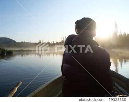 Fisherman man in rowing boat at lake 59328888