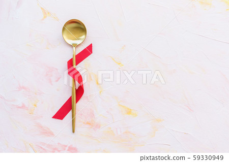Golden spoon wrapped with red ribbon on a pink background Golden spoon wrapped with red ribbon on a pink background 59330949