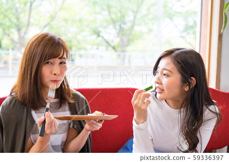 在一家咖啡館品嚐的年輕婦女 59336397