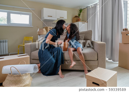 Mom with daughter pack things for relocation, mixed race family, African American daughter and Asian Mom with daughter pack things for relocation, mixed race family, African American daughter and Asian 59339589