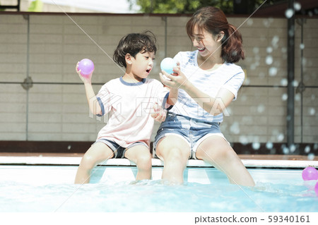 家庭,父母和孩子在游泳池玩耍 家庭,父母和孩子在游泳池玩耍 59340161