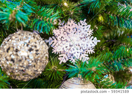 Christmas tree with silver bauble ornaments. Decorated Christmas tree closeup. Balls and illuminated 59341589
