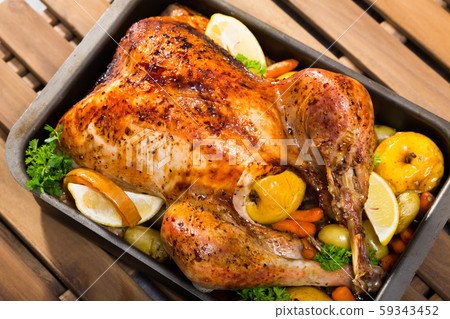 Close up of tasty cooked homemade turkey with apples, lemon and greens Close up of tasty cooked homemade turkey with apples, lemon and greens 59343452