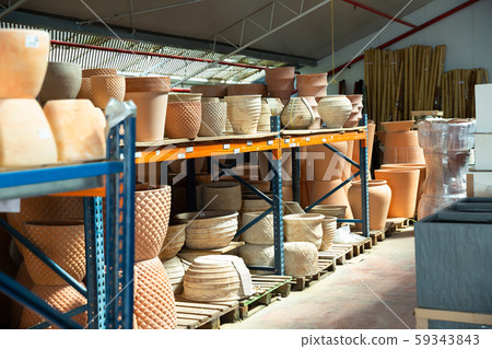 Clay pots and flower vases on racks in store 59343843