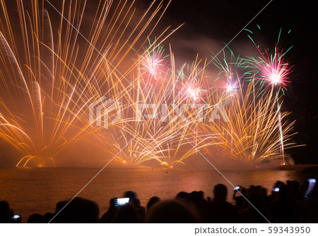 Bright firework show over water in dark sky Bright firework show over water in dark sky 59343950
