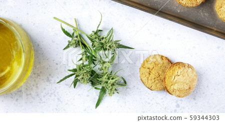 A panorama of cannabis butter cookies with marijuana buds and cannaoil, homemade healthy biscuits A panorama of cannabis butter cookies with marijuana buds and cannaoil, homemade healthy biscuits 59344303