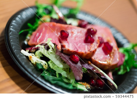 Slices of raw tuna with herbs and pomegranate 59344475