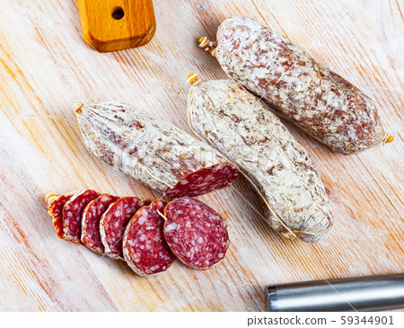 Italian cacciatori salami sausages on a wooden table Italian cacciatori salami sausages on a wooden table 59344901