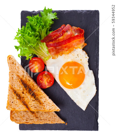 Top view of fried egg, bacon and grilled bread Top view of fried egg, bacon and grilled bread 59344952