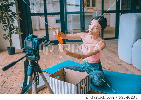 Fitness blogger showing resistance band while filming video Fitness blogger showing resistance band while filming video 59346235