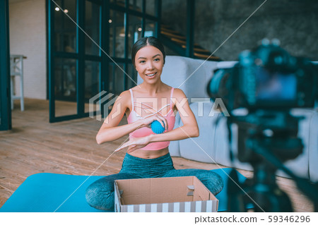 Slim fitness blogger filming video about massage ball Slim fitness blogger filming video about massage ball 59346296