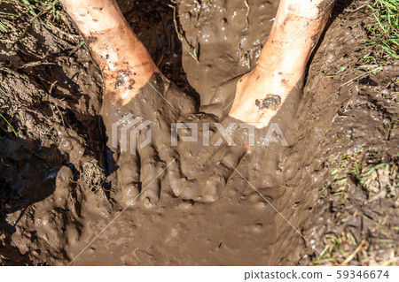 Boy working and playing in the mud Boy working and playing in the mud 59346674