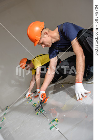 Installing a large ceramic tile. Installing a large ceramic tile. 59348704