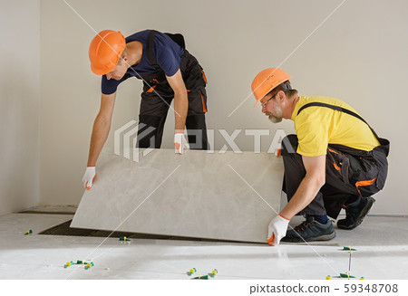 Installing a large ceramic tile. Installing a large ceramic tile. 59348708