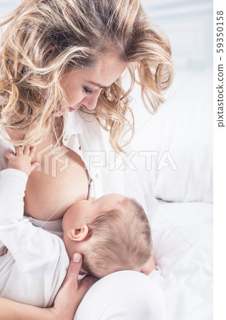 Mother breastfeeding her little baby in her arms 59350158