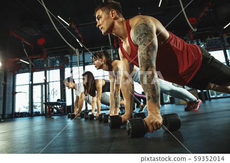 A group of muscular athletes doing workout at the gym 59352014