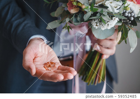 groom holding wedding rings groom holding wedding rings 59352485