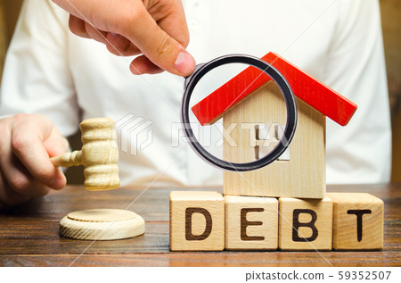 Wooden blocks with the word Debt and a miniature house with a judge's hammer. Confiscation of property for failure to pay the debt. The withdrawal of housing. Moratorium. Criminal penalty 59352507