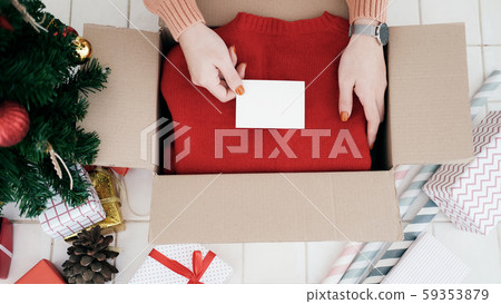 Woman hand put the chrismas card into christmas Woman hand put the chrismas card into christmas 59353879