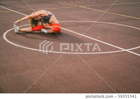 Woman Athlete Stretching Legs On Stadium. Female Runner Stretching Before Workout. Lifestyle 59355341