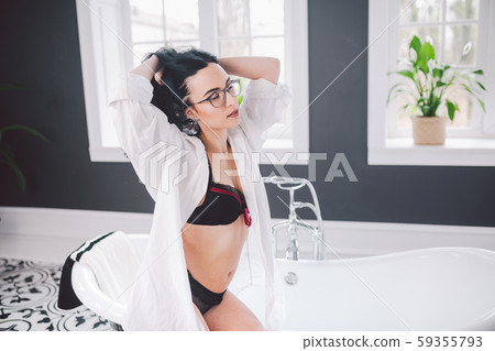 Woman In Bathroom. beautiful girl on bathtub in... - Stock Photo