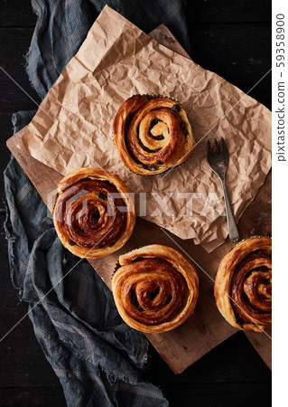 Fresh danish pastry with raisins on wood 59358900