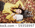 Young mother and baby lie on yellow leaves 59358997