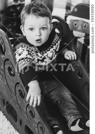 Little blonde boy playing with Christmas presents Little blonde boy playing with Christmas presents 59359990