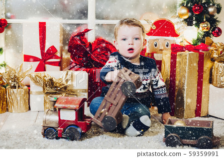 Little blonde boy playing with Christmas presents Little blonde boy playing with Christmas presents 59359991