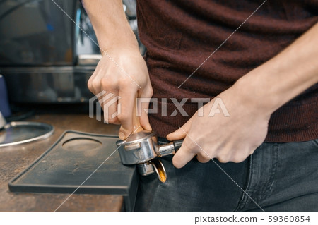 Closeup of coffee making process, hands of barista using a coffee machine Closeup of coffee making process, hands of barista using a coffee machine 59360854