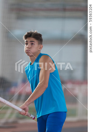 Pole vaulting indoors - young man running up holding a pole - took a deep breath Pole vaulting indoors - young man running up holding a pole - took a deep breath 59363104