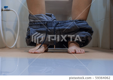 close up woman with constipation sitting on toilet. 59364062