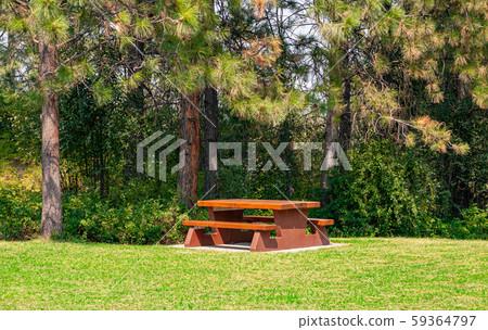 Rest area with wooden table on hike route in shadow of the trees. Rest area with wooden table on hike route in shadow of the trees. 59364797
