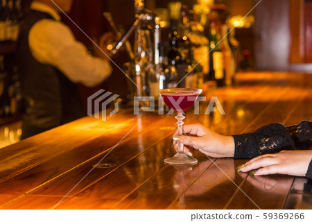 Woman drinking a cocktail at the bar counter Woman drinking a cocktail at the bar counter 59369266