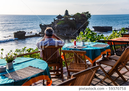 Indonesia, Bali, a restaurant overlooking Tanah Lot at sea, people waiting for sunset Indonesia, Bali, a restaurant overlooking Tanah Lot at sea, people waiting for sunset 59370758