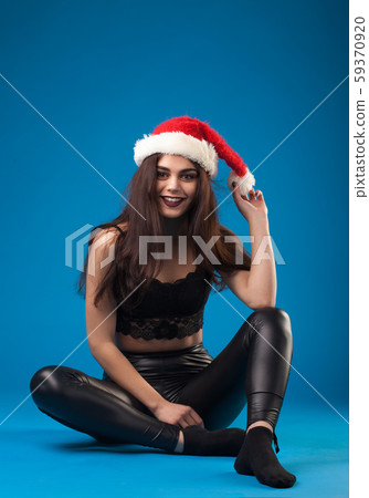attractive brunette in black leggings and santa claus hat 59370920