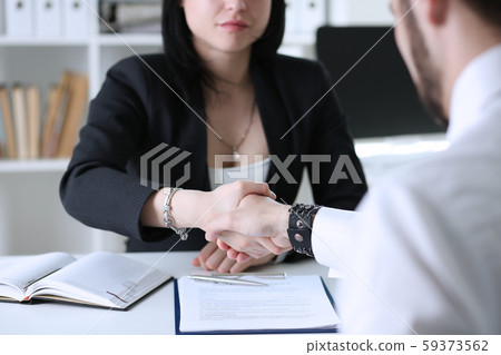 Businessman and woman shake hands as hello in office Businessman and woman shake hands as hello in office 59373562
